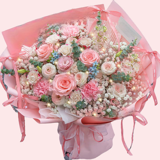 Pink carnations and roses with baby's breath and small blue flowers bouquet