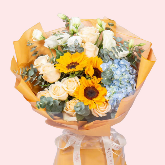 Two sunflowers with champagne roses, blue hydrangeas, and eucalyptus leaves